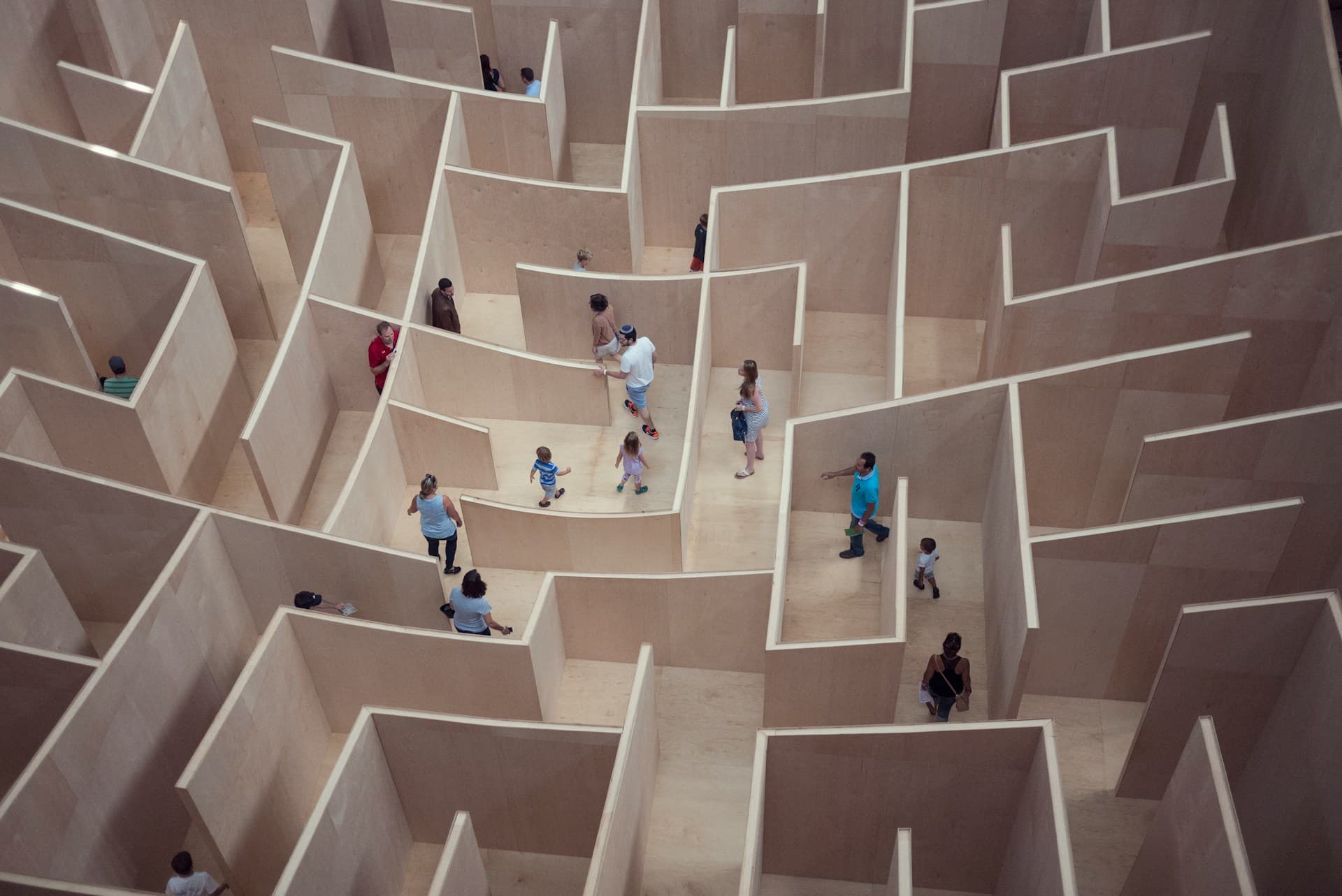 People finding their way through a maze of identical walls